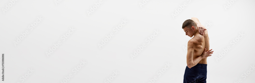 Obraz premium Back pain. Rear view of shirtless young man with relief strong back isolated over white background. Concept of sportive lifestyle, body and heath care, youth. Banner. Empty space to insert text, ad