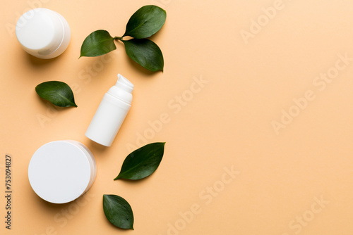 Organic cosmetic products with green leaves on color background. Copy space, flat lay