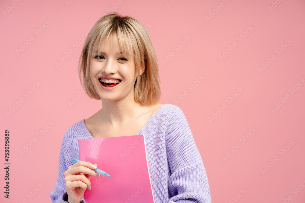 Excited, beautiful young woman wearing casual outfit holding book, looking at camera Excited, beautiful young woman wearing casual outfit holding book, looking at camera