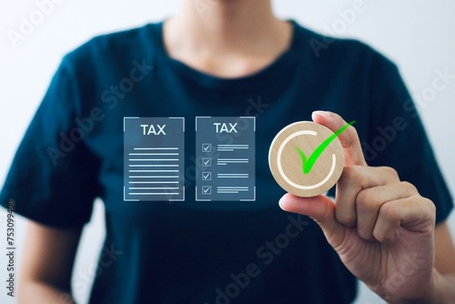 Businessman holds a wooden board with the correct sign and an online personal income tax return form to pay taxes.