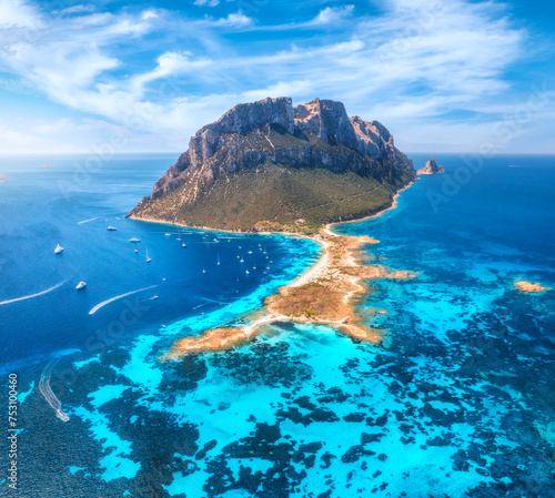 Aerial view of sandy beach on amazing Tavolara island in Sardinia, Italy. Top view of clear blue sea, boat, yachts, mountain, sky, clouds at summer sanny day. Colorful seascape with turquoise water