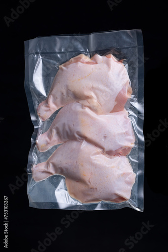 Chicken thighs in vacuum packed sealed for sous vide cooking, on black background