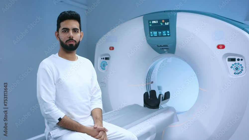 Indian patient undergoing magnetic resonance tomography. Patient getting ready for tomography examination. MRI equipment with button for adjusting. Smiling patient before or after procedure. Indian patient undergoing magnetic resonance tomography. Patient getting ready for tomography examination. MRI equipment with button for adjusting. Smiling patient before or after procedure.