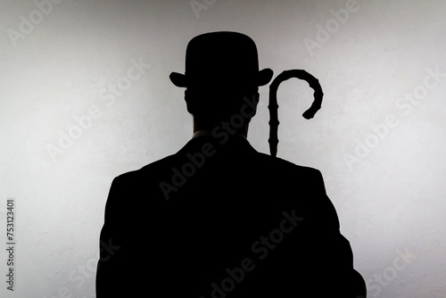 Backlit Portrait of English Gentleman in Bowler Hat Holding Umbrella. Vintage Style of British Spy Hero and Crime Fighter.