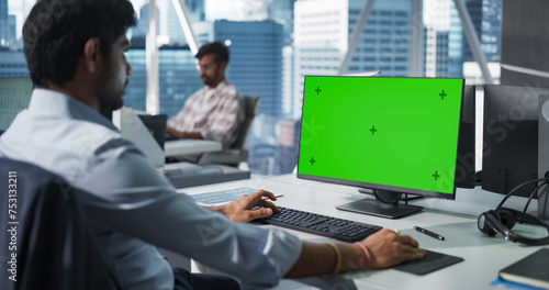 Indian Chief Financial Officer Working on Desktop Computer with Green Screen Mock Up Display. Young South Asian Specialist Analyzing Corporate Banking Account, Researching Investment Opportunities