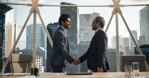 Two Young South Asian Businessmen Shaking Hands in a Corporate Office Conference Room. Operations Manager and Team Leader Discussing Creative Business Solutions for Their Company Project photo