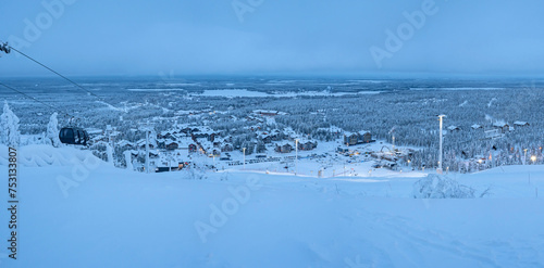 Panoramic view from the ski slope of the village of Levi, Finland, covered with snow in the evening lights.
