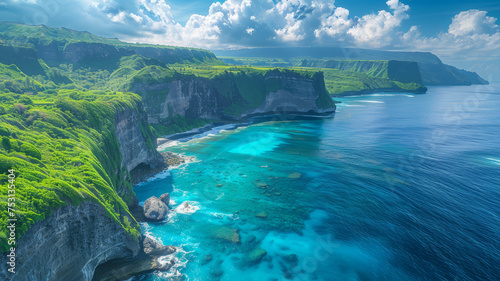Aerial shot of vibrant green cliffs descending into the stunning turquoise waters of a serene tropical coastline..
