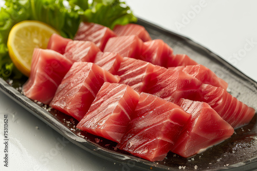Slices of fresh salmon sashimi presented on a ceramic plate, garnished with herbs, ready for a Japanese cuisine experience..