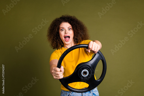 Photo of young surprised woman funny chevelure hair first time fast speed driving automobile alone isolated on khaki color background