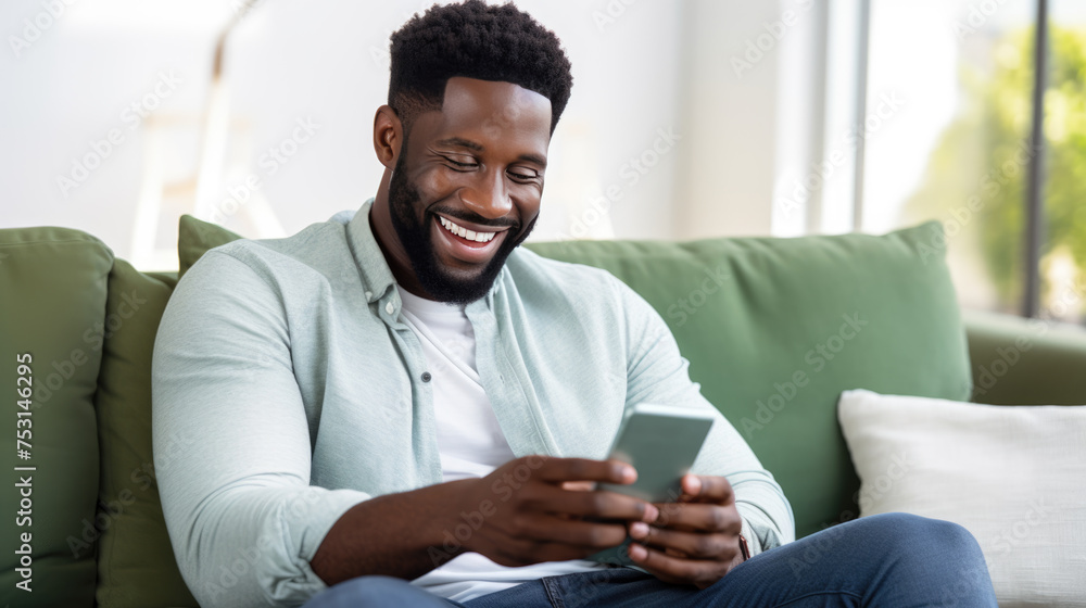 Happy man using a smartphone while comfortably seated on a couch Happy man using a smartphone while comfortably seated on a couch