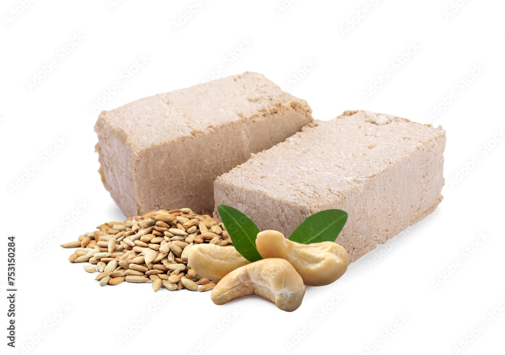 Tasty halva, peeled sunflower seeds, cashews and green leaves isolated on white Tasty halva, peeled sunflower seeds, cashews and green leaves isolated on white