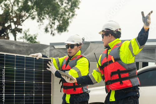 engineer men inspect modules of photovoltaic cell panels. Industrial Renewable energy of green power. workers prepare materials before construction on site with the stack of panels at background.