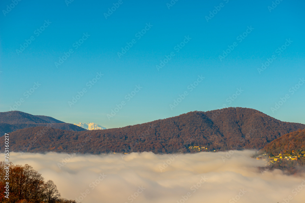 Mountain View over Lake Lugano with Cloudscape and Sunlight and Clear Sky and Monte Rosa in Lugano, Ticino in Switzerland.
