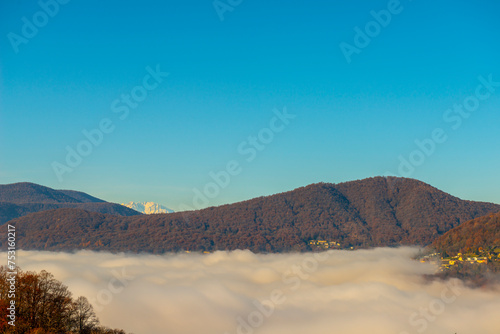 Mountain View over Lake Lugano with Cloudscape and Sunlight and Clear Sky and Monte Rosa in Lugano  Ticino in Switzerland.