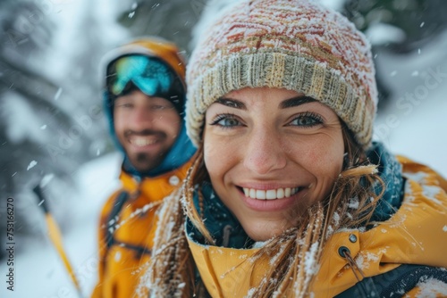 A man and a woman are standing in the snow, both smiling brightly. They are wearing winter clothing and enjoying the snowy environment around them © lublubachka