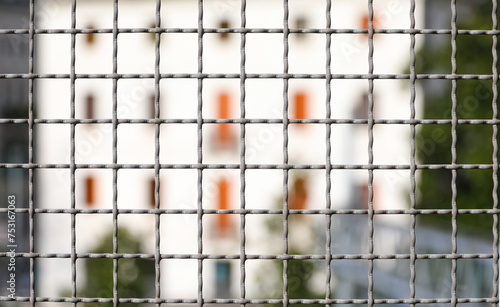 fence separating the border and the building intentionally blurred in the background photo