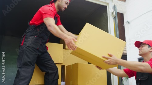 Close up delivery man stand on truck and send parcel or box to his co-worker during transport the product to customer house.