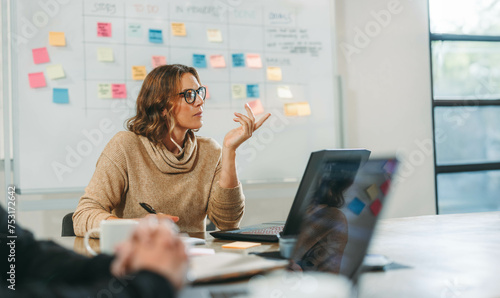 Woman leading a creative brainstorming meeting in a tech company office