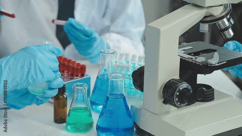 Doctor hand taking a blood sample tube from a rack with machines of analysis in the lab background, Technician holding blood tube test in the research laboratory. Doctor hand taking a blood sample tube from a rack with machines of analysis in the lab background, Technician holding blood tube test in the research laboratory.