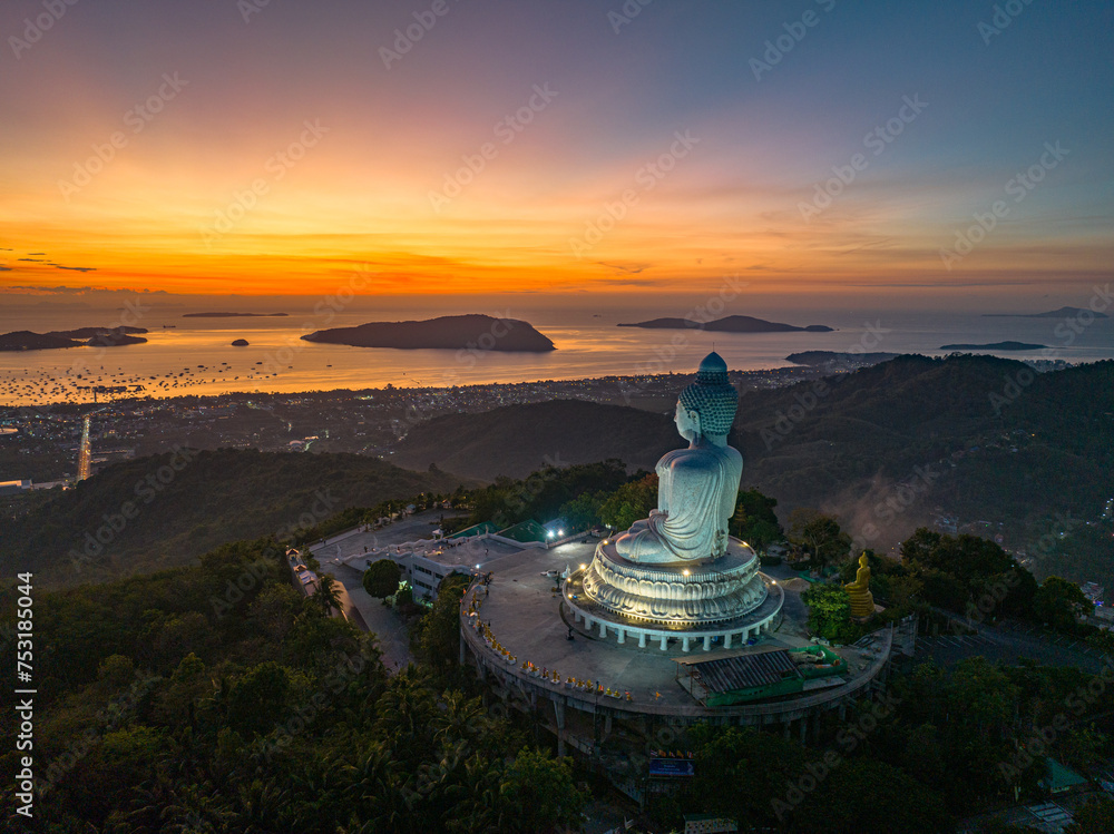 Aerial view scenery yellow light at horizon at sunrise in front of Phuket Big Buddha.the golden sun shines through the clouds..The beauty of the statue fits perfectly with the charming nature. Aerial view scenery yellow light at horizon at sunrise in front of Phuket Big Buddha.the golden sun shines through the clouds..The beauty of the statue fits perfectly with the charming nature.