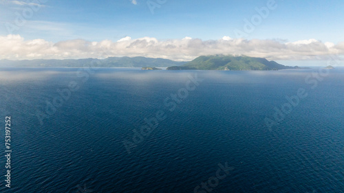 Drone view of Blue Sea Surface under blue sky and clouds. Romblon, Philippines.