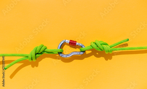 two ropes with secure knots are connected by a carabiner. Equipment for rock climbing and mountaineering. reliable connection. concept of reliability and strength.