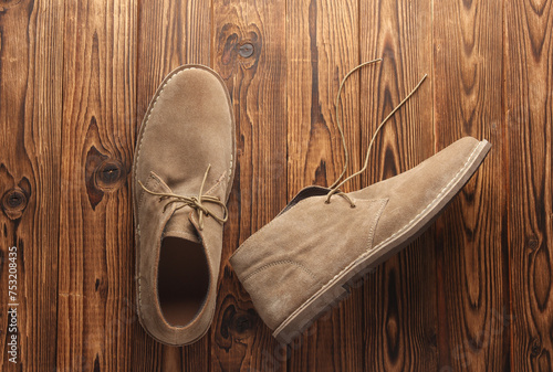 Suede desert boots on wooden background photo