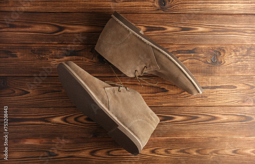 Suede desert boots on wooden background photo