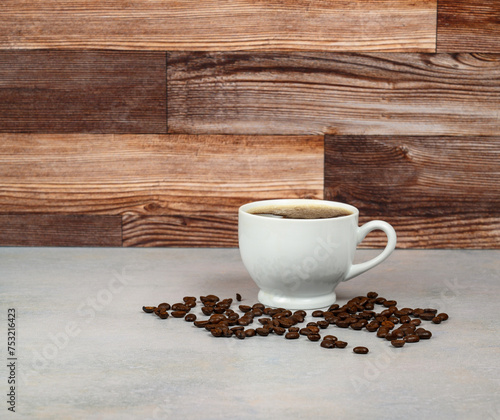 Coffee in white porcelain cup surrounded by coffee beans 