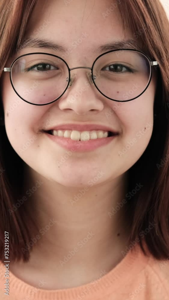 With sheer happiness and a beaming smile, a teenage girl looks directly into the camera, exuding joy and positivity. Her eyes sparkle with delight, and her radiant smile lights up the frame.