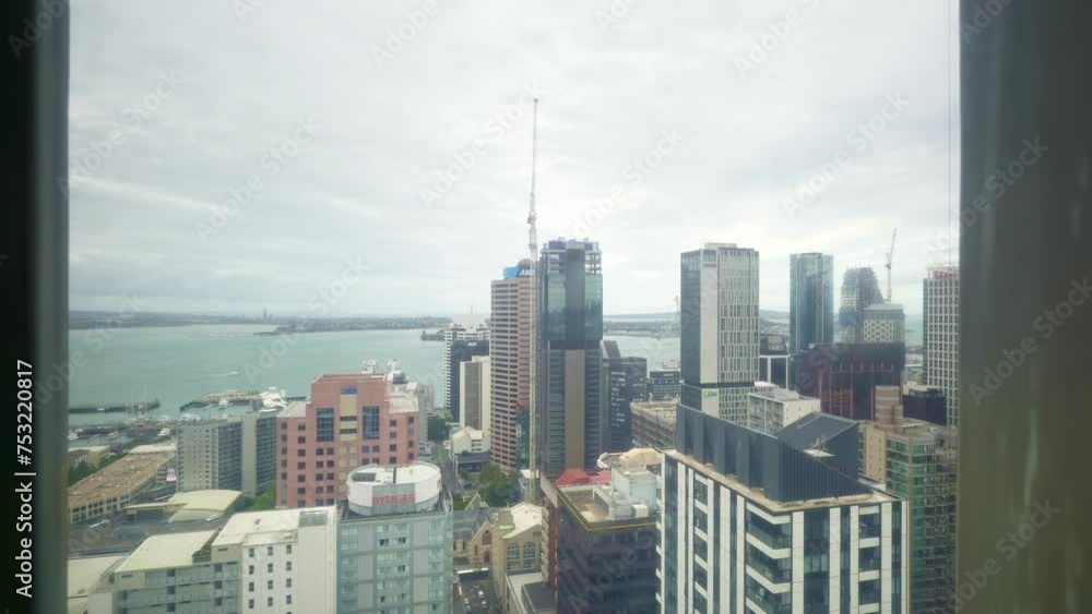 Going up in elevator to top of Sky Tower. Auckland downtown seen from above. New Zealand. modern commercial buildings in city center. Going up in elevator to top of Sky Tower. Auckland downtown seen from above. New Zealand. modern commercial buildings in city center.