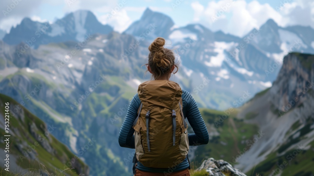 Woman Standing on Mountain Top With Backpack