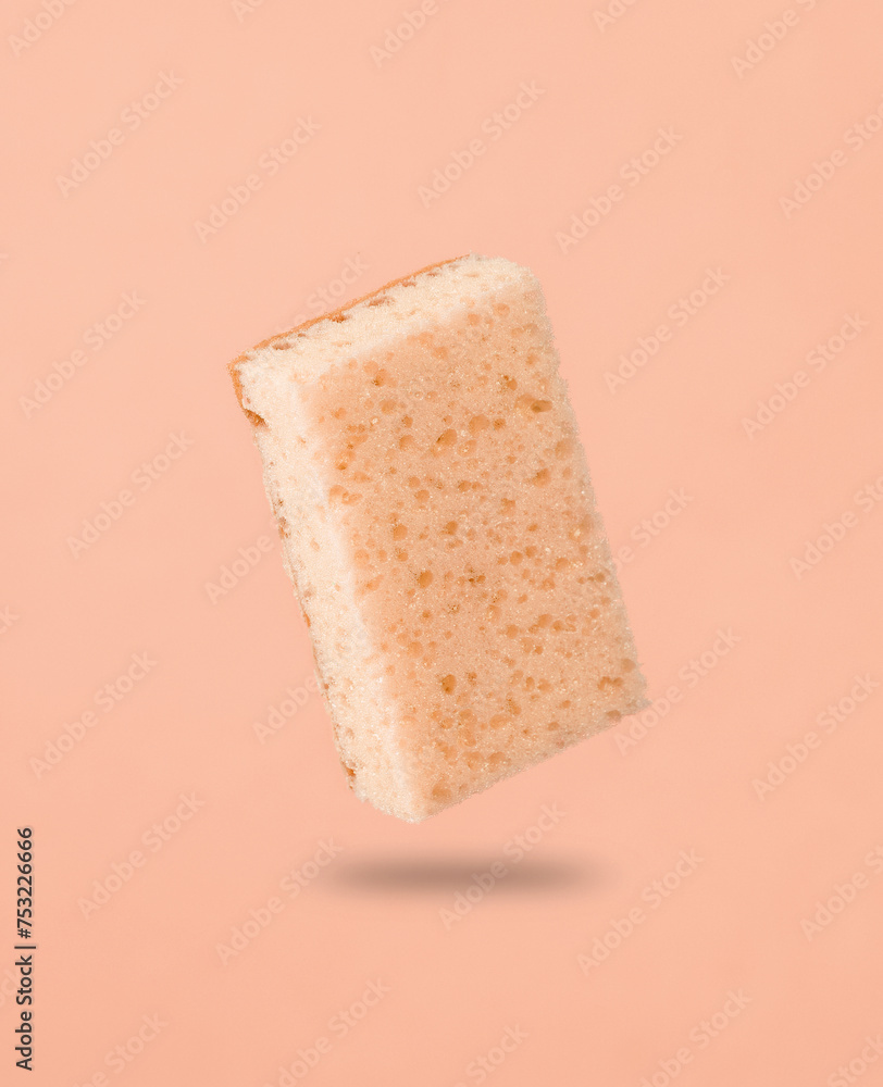 Sponge levitating on pink background with a shadow. Cleaning concept