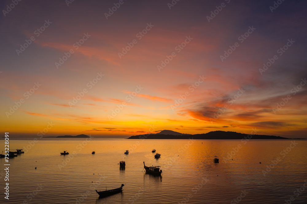 aerial view scenery yellow sky over the island at sunrise..beautiful sky of sunrise at Rawai beach Phuket Thailand.image for travel concept. cloud in sky background..