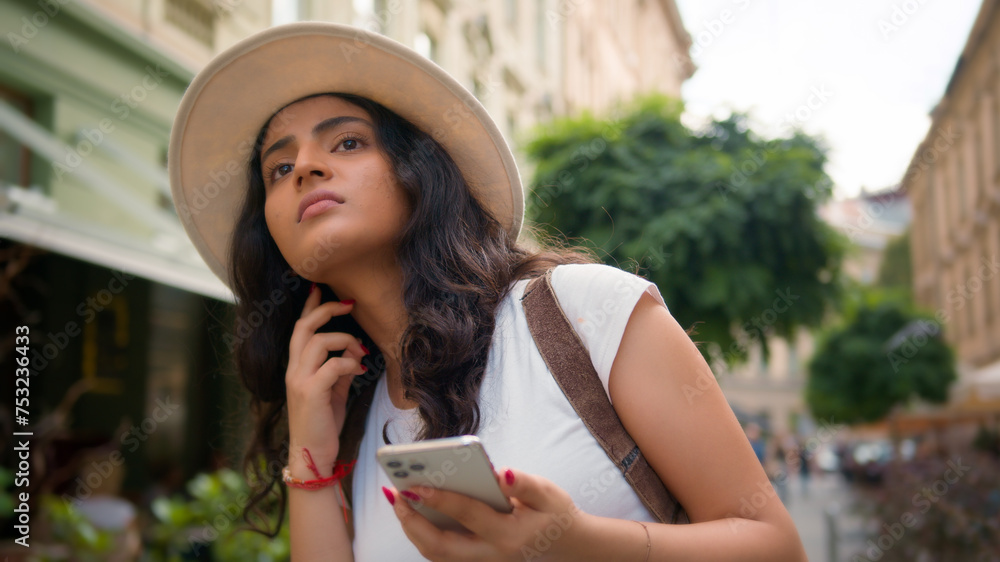 Confused Indian Arabian woman travel alone lost female tourist traveler girl on street sightseeing use mobile phone gps app looking around city trying find street explore town with smartphone outside