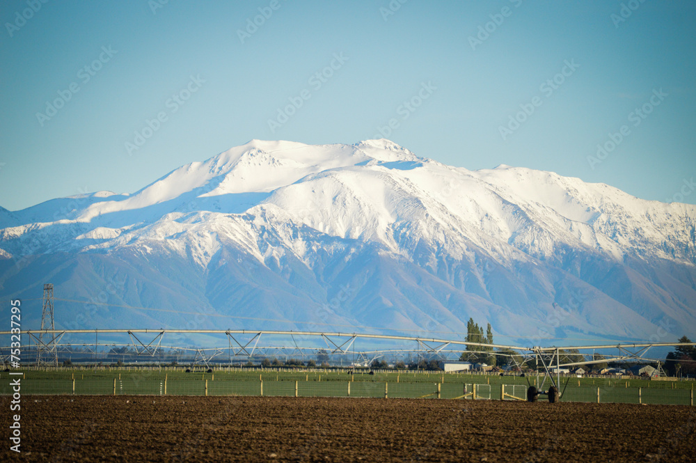 Naklejka premium Snow-capped Mountain with Pivot Irrigation in the foreground