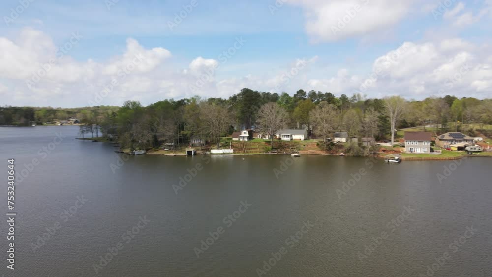 Countryside lake with traditional American houses on shoreline and boat docks, amazing greenery and natural landscape in sunshine Countryside lake with traditional American houses on shoreline and boat docks, amazing greenery and natural landscape in sunshine