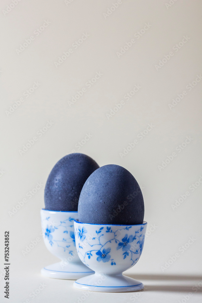 Eggs colored with wine in an egg cup on a light background. Easter concept.