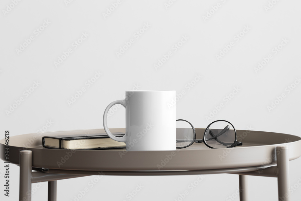 White mug mockup with workspace accessories on the beige table. White mug mockup with workspace accessories on the beige table.
