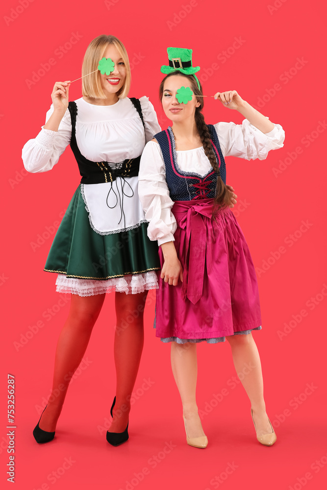 Happy women celebrating St. Patrick's Day on red background