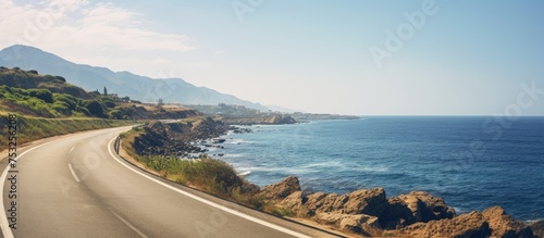 Scenic Coastal Drive: Seafront Road Meandering Along the Serene Ocean Horizon © vxnaghiyev