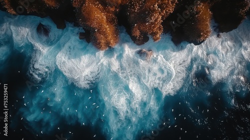 an aerial view of a body of water with a bunch of rocks sticking out of the side of the water.