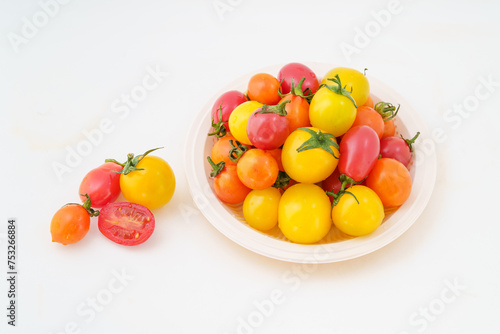 Fresh small persimmons of various colors on white background