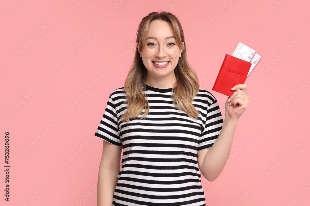 Happy young woman with passport and ticket on pink background Happy young woman with passport and ticket on pink background