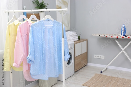 Laundry room interior with washing machine and clothes on rack © New Africa