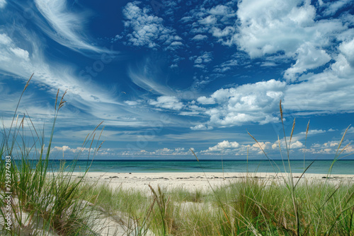 Pristine beach with white sand  dune grass  and a stunning blue sky with wispy clouds.