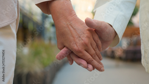 Close up unrecognizable wrinkled hand elderly old senior aged man and woman married couple husband wife holding hands separated palms outside marriage problems family relationship divorce separation