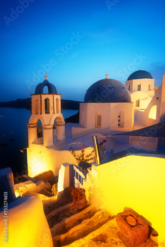 traditional greek village Oia of Santorini, with blue domes of churches at night, Greece