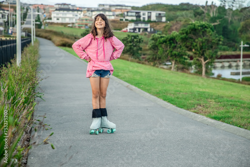 portrait of young child or teen girl roller skating outdoors, firness, wellbeing, active healthy lifestyle photo